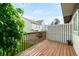 Outdoor back deck with wooden railing and partial view of houses at 9946 W Cornell Pl, Lakewood, CO 80227
