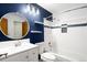 Bright bathroom featuring white subway tile, modern vanity, and a blue accent wall for a touch of color at 9946 W Cornell Pl, Lakewood, CO 80227