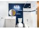 Bathroom featuring white subway tile, modern vanity, and a blue accent wall with patterned tile floor at 9946 W Cornell Pl, Lakewood, CO 80227