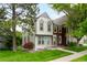 Charming two-story townhome with light-colored siding, gray trim, mature trees and a lush green lawn at 9946 W Cornell Pl, Lakewood, CO 80227