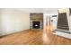 Open-concept living room featuring a stone fireplace, hardwood floors, and stairway to upper level at 9946 W Cornell Pl, Lakewood, CO 80227