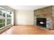 Cozy living room featuring a stone fireplace, hardwood floors, and large windows for ample natural light at 9946 W Cornell Pl, Lakewood, CO 80227