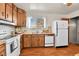 Classic kitchen design with wood cabinetry, white appliances, and a bright window overlooking outdoors at 5505 Tucson St, Denver, CO 80239