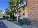 Multi-level condo building with brick exterior and multiple balconies with tree lined sidewalks at 430 Zang St # 4-102, Lakewood, CO 80228