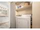 Convenient laundry area with washer, dryer, and storage shelves next to the bathroom at 430 Zang St # 4-102, Lakewood, CO 80228