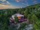 Modern mountain home with walls of windows is privately nestled among trees and surrounded by a forest at 8791 Grizzly Way, Evergreen, CO 80439