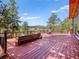 Wide angle of an expansive outdoor deck with built-in seating and outdoor furniture with scenic wooded views at 8791 Grizzly Way, Evergreen, CO 80439