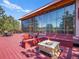 Expansive deck featuring a stone fire pit, seating, and full-wall glass doors to the interior at 8791 Grizzly Way, Evergreen, CO 80439