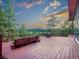 Expansive wooden deck with built-in seating and outdoor furniture offers scenic views of golf course and mountains at 8791 Grizzly Way, Evergreen, CO 80439
