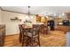 Open floor plan from kitchen to dining featuring hardwood floors, breakfast bar, and stainless appliances at 8791 Grizzly Way, Evergreen, CO 80439