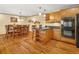 Kitchen with wood cabinets, stainless appliances, granite countertops, hardwood floors and open to the dining room at 8791 Grizzly Way, Evergreen, CO 80439
