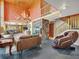 Spacious open-concept living area with fireplace, a wall of windows, and antler chandelier at 8791 Grizzly Way, Evergreen, CO 80439