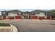 Street view of gray townhouses featuring red garage doors and manicured landscaping at 9300 E Florida Ave # 906, Denver, CO 80247