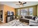 Open-concept living room with a large sectional couch, fireplace, and bright windows at 9300 E Florida Ave # 906, Denver, CO 80247