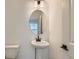 Stylish powder room featuring a pedestal sink, modern fixtures, and a decorative oval mirror at 1755 Peak Loop, Broomfield, CO 80023