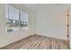 Sunlit bedroom features wood floors and a large window with community views at 1755 Peak Loop, Broomfield, CO 80023