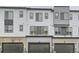 Exterior view of townhomes showcasing garages and neutral paint at 1755 Peak Loop, Broomfield, CO 80023