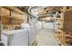 Unfinished basement with laundry area, open ceiling, brick wall, and concrete floor at 553 N Logan St, Denver, CO 80203