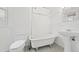 Bathroom featuring a vintage-style tub, a modern toilet, a pedestal sink, and neutral tiling at 553 N Logan St, Denver, CO 80203