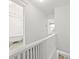 Upstairs hallway with railing leading to a bedroom and bathroom at 553 N Logan St, Denver, CO 80203