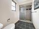 Bathroom with tiled shower, black tile floor, white walls, and a window at 8133 W Quarto Ave, Littleton, CO 80128