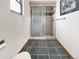 Bathroom with tiled shower, black tile floor, white walls, and a window at 8133 W Quarto Ave, Littleton, CO 80128