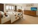 Bright bedroom with a patterned comforter and a dresser with a television at 8133 W Quarto Ave, Littleton, CO 80128