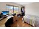 Bedroom with computer desk, hardwood floors, and large window view at 8133 W Quarto Ave, Littleton, CO 80128