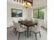 Elegant dining room featuring a dark wood table, six neutral chairs, chandelier lighting, and a large window with lush views at 8133 W Quarto Ave, Littleton, CO 80128