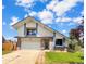 Charming home featuring white siding, brick accents, an attached garage, and a well-manicured lawn at 8133 W Quarto Ave, Littleton, CO 80128