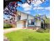 Charming home featuring white siding, brick accents, an attached garage, and a well-manicured lawn at 8133 W Quarto Ave, Littleton, CO 80128