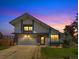 Charming two-story home with well-maintained lawn, brick accents, and an attached two-car garage during a scenic sunset at 8133 W Quarto Ave, Littleton, CO 80128
