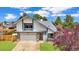 Charming two-story home with a brick accent, attached garage, and mature landscaping at 8133 W Quarto Ave, Littleton, CO 80128