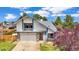 Charming two-story home with an attached garage and blossoming tree at 8133 W Quarto Ave, Littleton, CO 80128