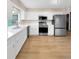 Modern kitchen featuring stainless steel appliances, white cabinets, and wood flooring at 8133 W Quarto Ave, Littleton, CO 80128