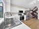 Well-lit kitchen with stainless appliances, white cabinetry, and wood-look flooring at 8133 W Quarto Ave, Littleton, CO 80128