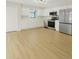 Modern kitchen featuring white cabinets, stainless steel appliances, and sleek countertops, complemented by light wood flooring at 8133 W Quarto Ave, Littleton, CO 80128