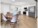 Bright kitchen and dining area with stainless appliances, white cabinets, and wood floors at 8133 W Quarto Ave, Littleton, CO 80128