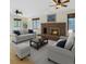 Comfortable living room features a brick fireplace, two sofas, a coffee table, and ample natural light from multiple windows at 8133 W Quarto Ave, Littleton, CO 80128