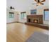 Spacious living room with a brick fireplace, ceiling fans, and ample natural light at 8133 W Quarto Ave, Littleton, CO 80128