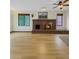 Cozy living room with hardwood floors, brick fireplace, ceiling fan, and multiple bright windows at 8133 W Quarto Ave, Littleton, CO 80128