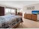 Bright main bedroom with a wooden dresser, a large window, and wood laminate flooring at 8133 W Quarto Ave, Littleton, CO 80128