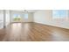 Bright living room featuring wood floors, white walls, large windows, and a ceiling fan at 42966 Colonial Trl, Elizabeth, CO 80107