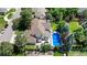 A beautiful aerial view of a home's roof, in-ground swimming pool and lush landscaping at 5955 Blue Sage Way, Littleton, CO 80123