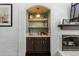 Charming bar area features a white brick archway with shelves and dark wood cabinets at 5955 Blue Sage Way, Littleton, CO 80123