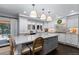Bright kitchen with white cabinets, gray island, stainless appliances, and modern pendant lighting at 5955 Blue Sage Way, Littleton, CO 80123