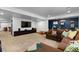 Open concept living room with neutral carpeting, brown couches, and built-in storage at 5955 Blue Sage Way, Littleton, CO 80123