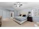 Bright main bedroom featuring a plush bed, ample closet space, and comfortable carpeting at 5955 Blue Sage Way, Littleton, CO 80123