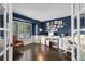 Well-lit home office featuring dark blue walls, a large window, and wood floors at 5955 Blue Sage Way, Littleton, CO 80123