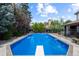 Large in-ground pool with a diving board surrounded by a patio and mature landscaping at 5955 Blue Sage Way, Littleton, CO 80123